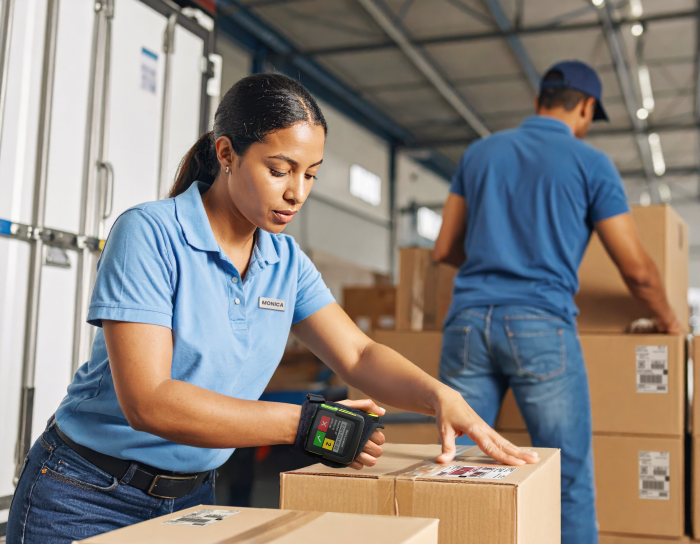 Worker unloading parcels with a back-of-hand wearable scanner